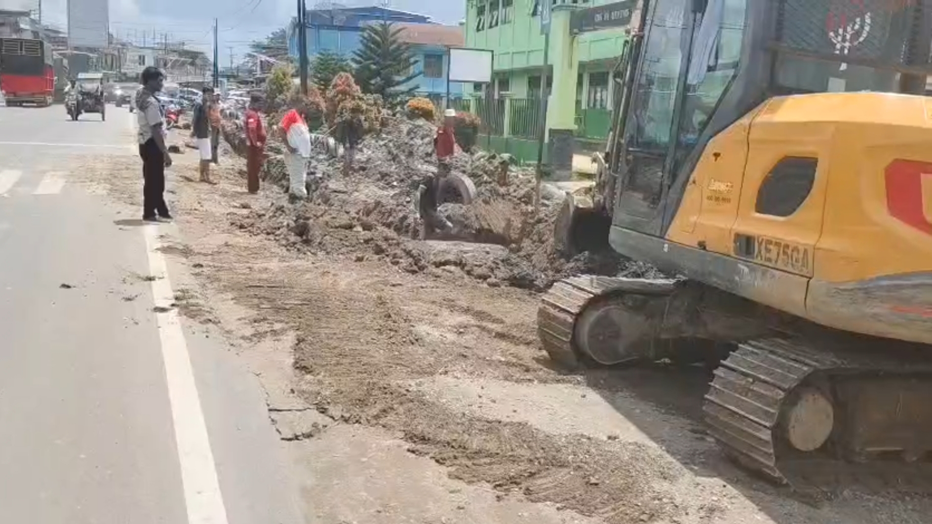 Alat berat melakukan pendalaman dan pelebaran saluran drainase didepan SDN 1 Bayung Lencir.